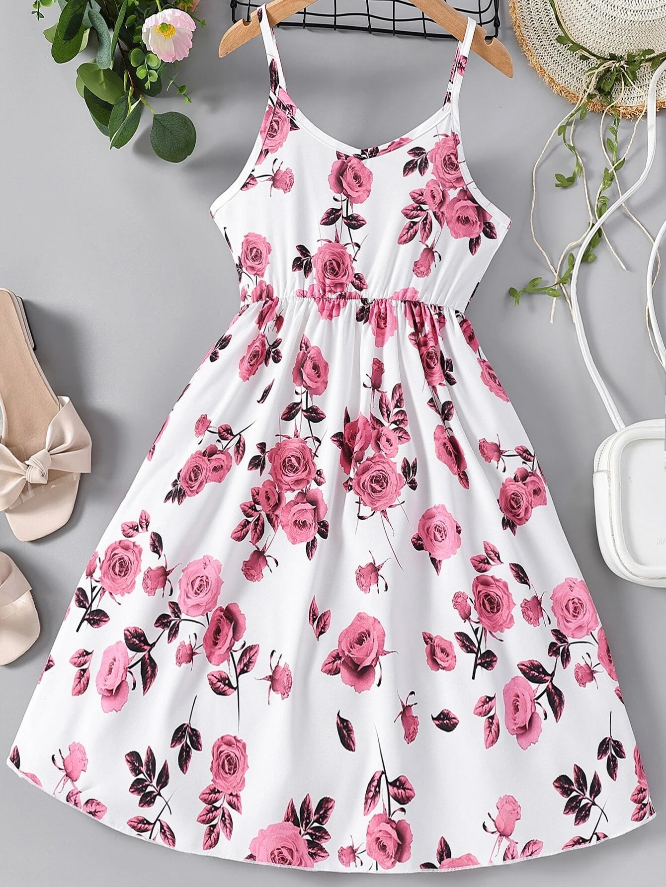 Vestido corto blanco floral con tirantes para niña, vista frontal mostrando estampado floral rosa y falda campana.