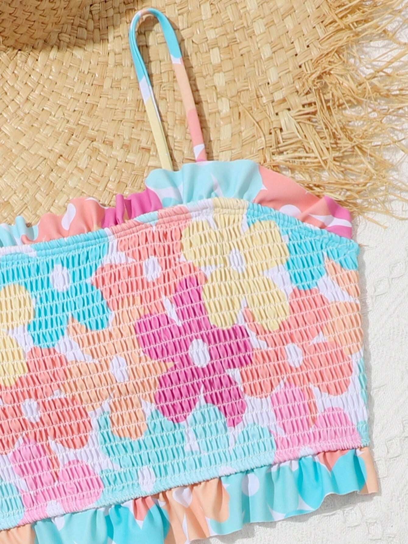 Detalle del top del bikini para niñas con efecto nido de abeja y volantes en el borde.
