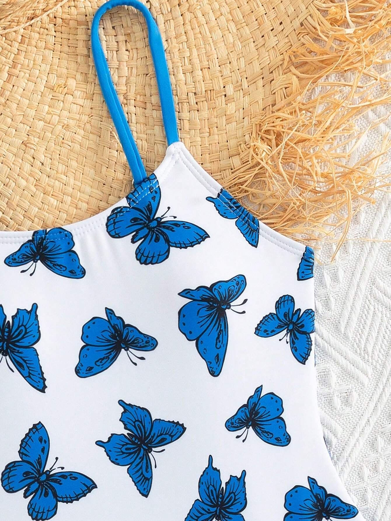 Detalle de los tirantes y el estampado de mariposas azules.