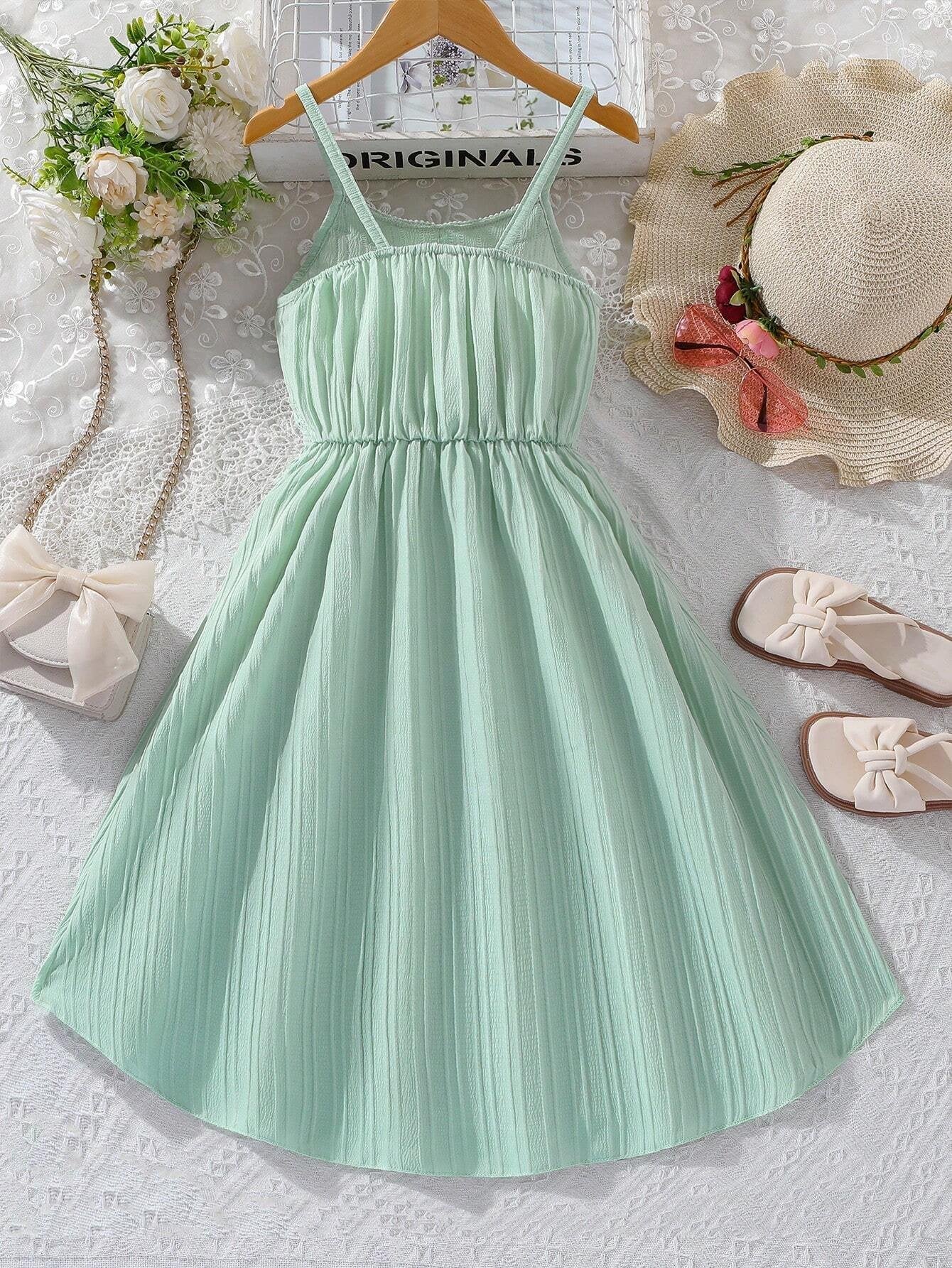 Vista trasera del vestido verde con tirantes finos y falda acampanada para niñas.