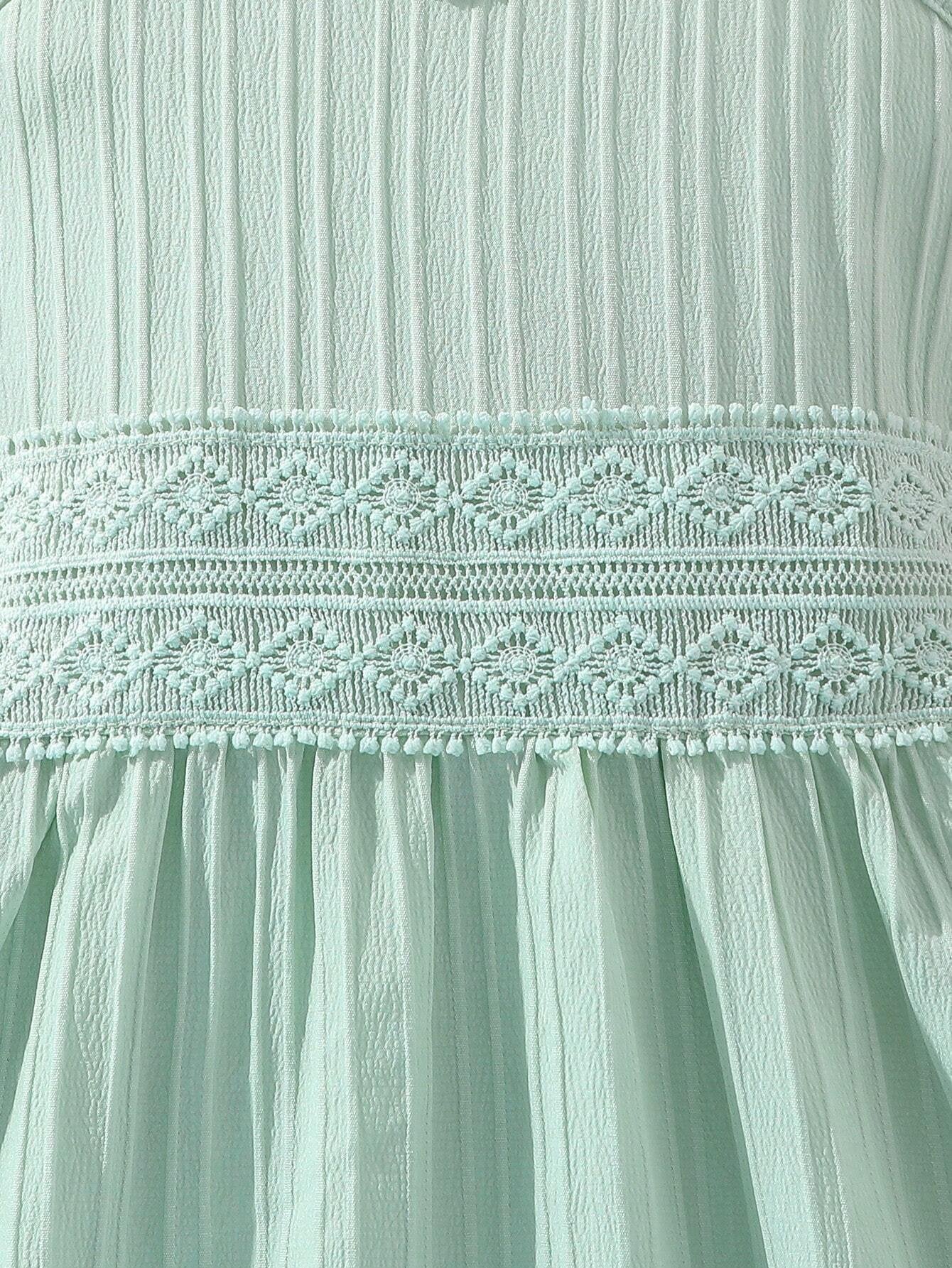 Detalle del encaje en la cintura del vestido verde con tirantes para niñas.