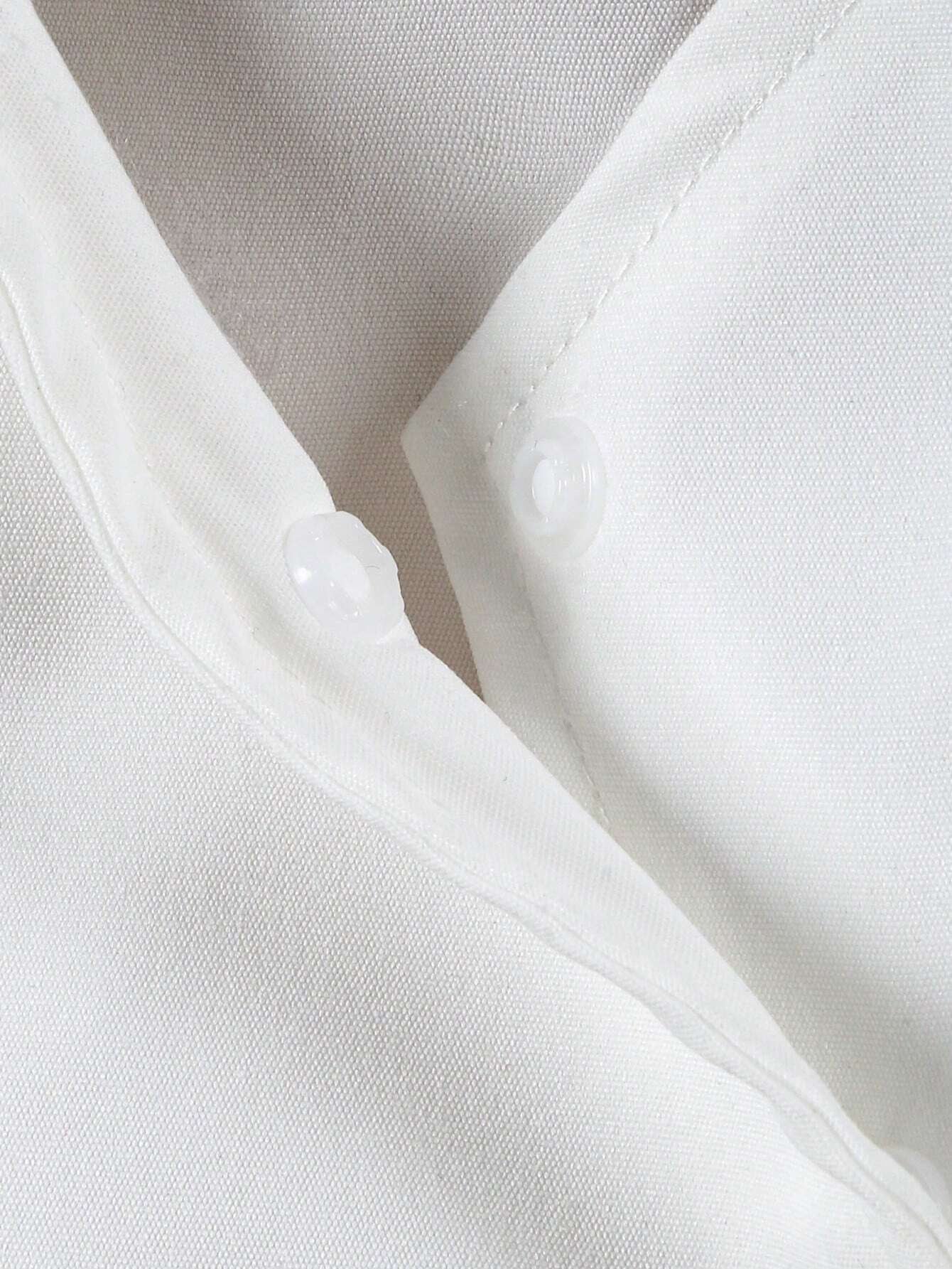 Detalle del escote en "V" con broche interno del vestido blanco para niñas.