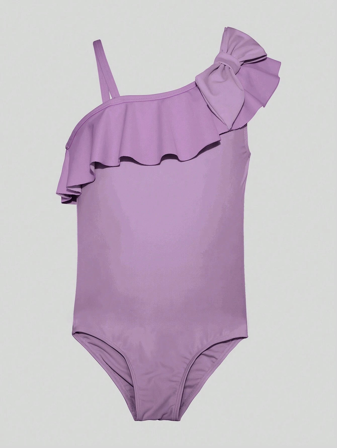 Imagen del traje de baño morado sobre fondo blanco, destacando el detalle del lazo y volante en el hombro.