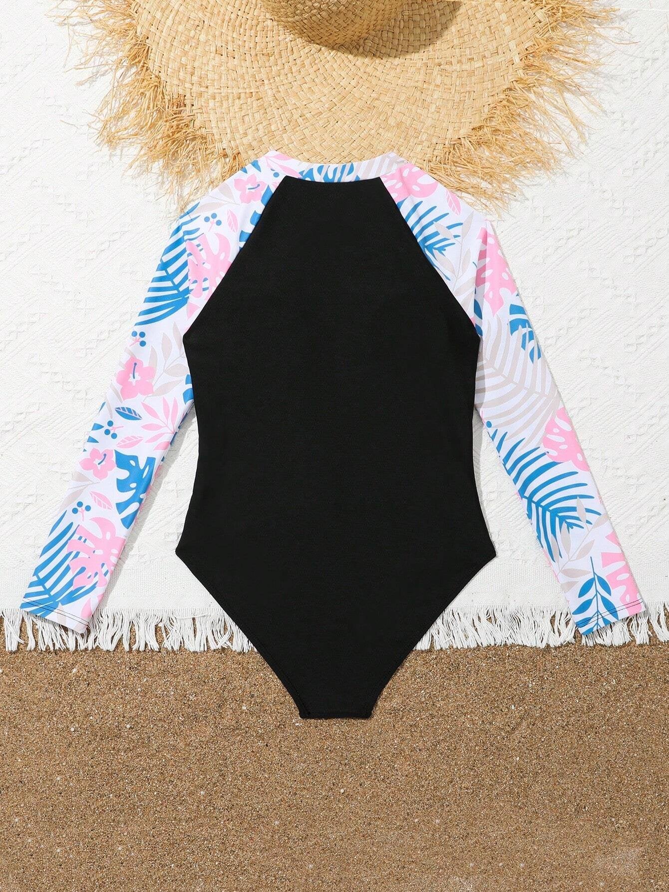 Traje de baño exhibido en la arena con detalles tropicales.