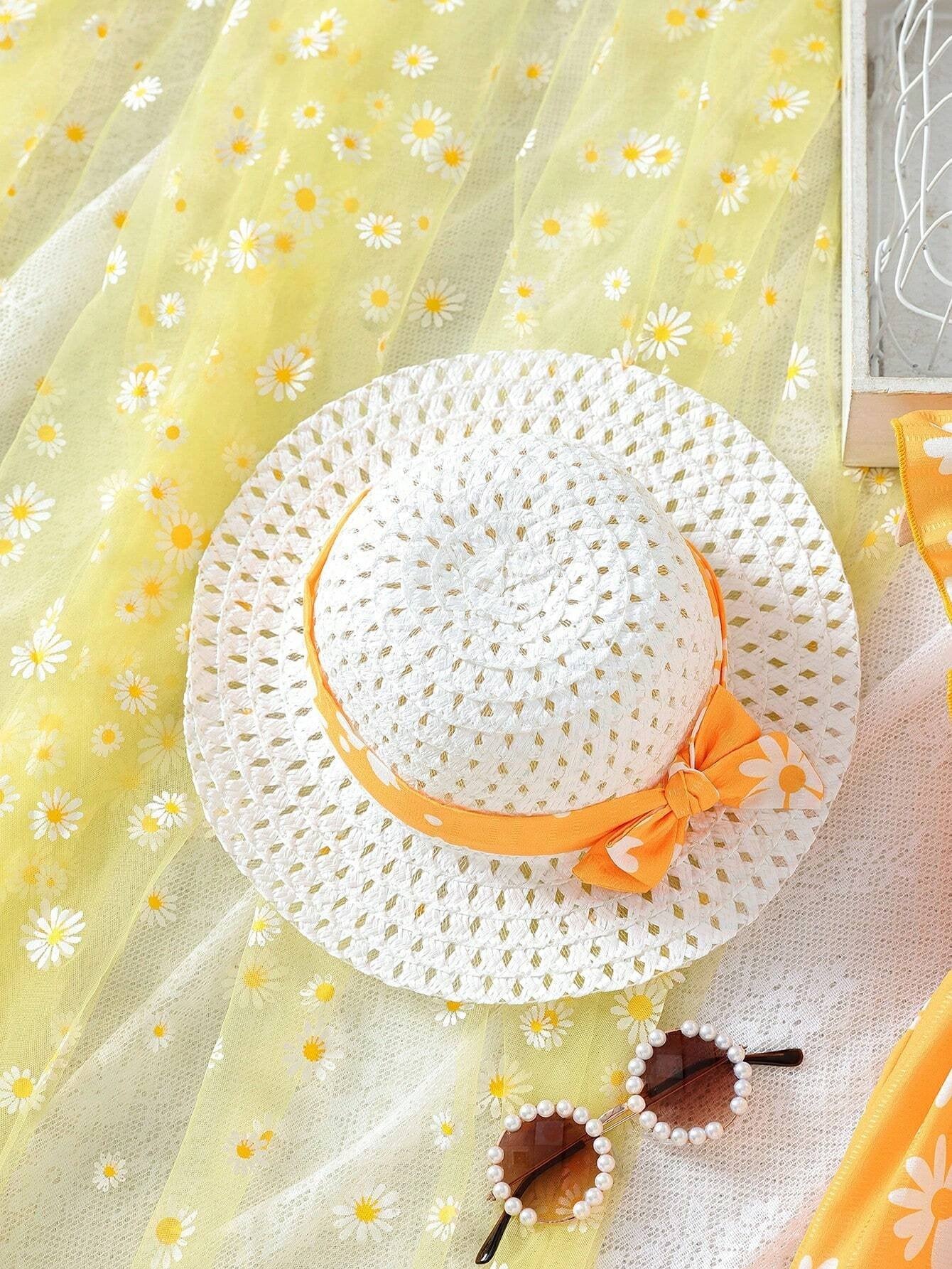 Sombrero blanco de paja con listón amarillo a juego con el vestido.