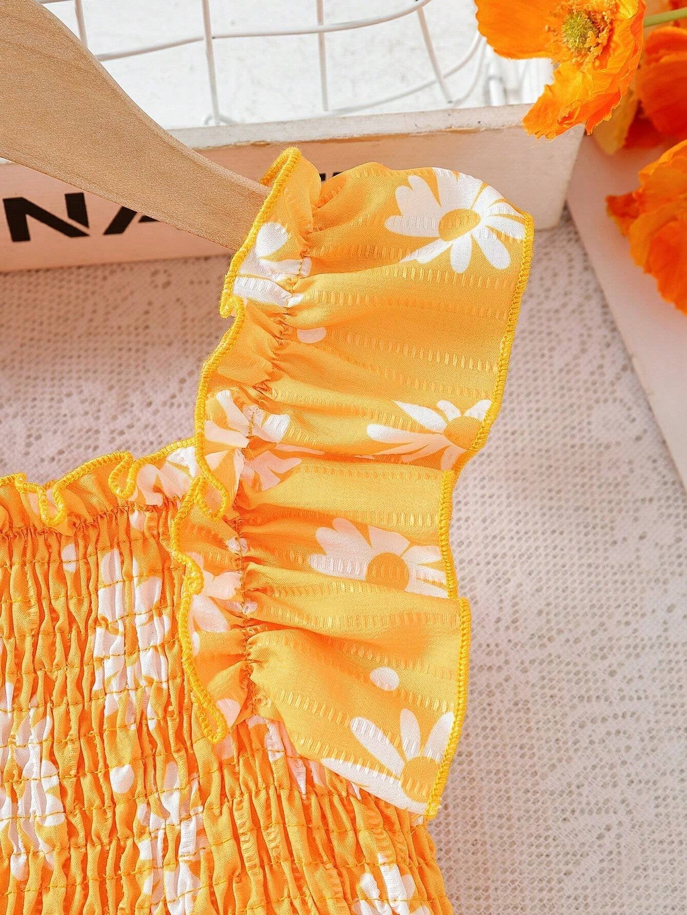 Primer plano de los volantes en los hombros del vestido floral.