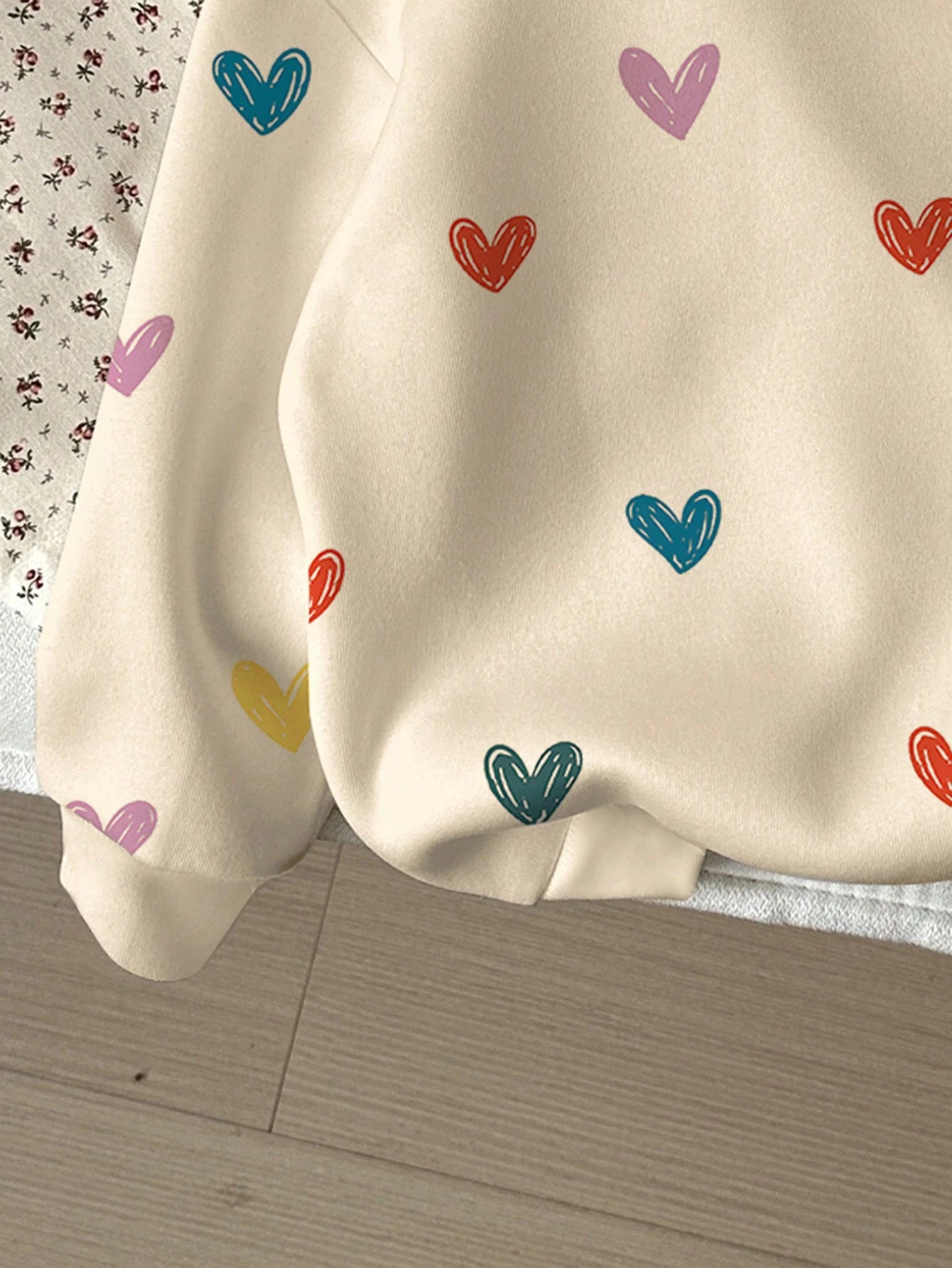 Puño y tejido de la sudadera infantil con diseño de corazones.