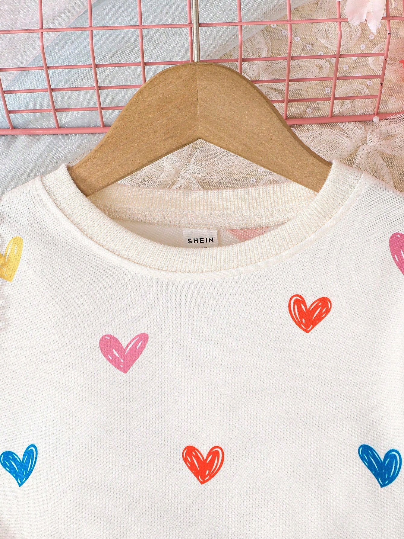 Detalle del estampado de corazones en la sudadera del vestido infantil.