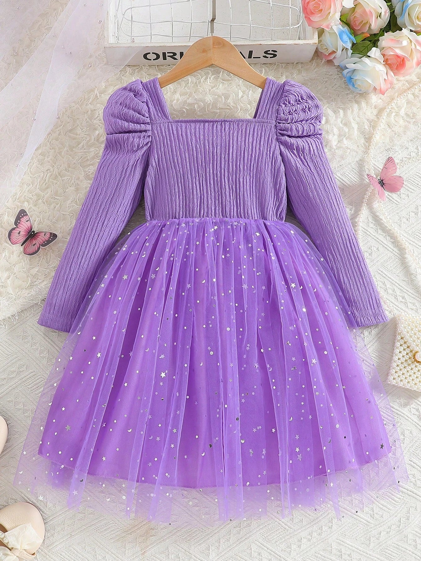 Vestido morado con tul y lazo para niña, vista trasera mostrando el corte campana y textura del tejido.
