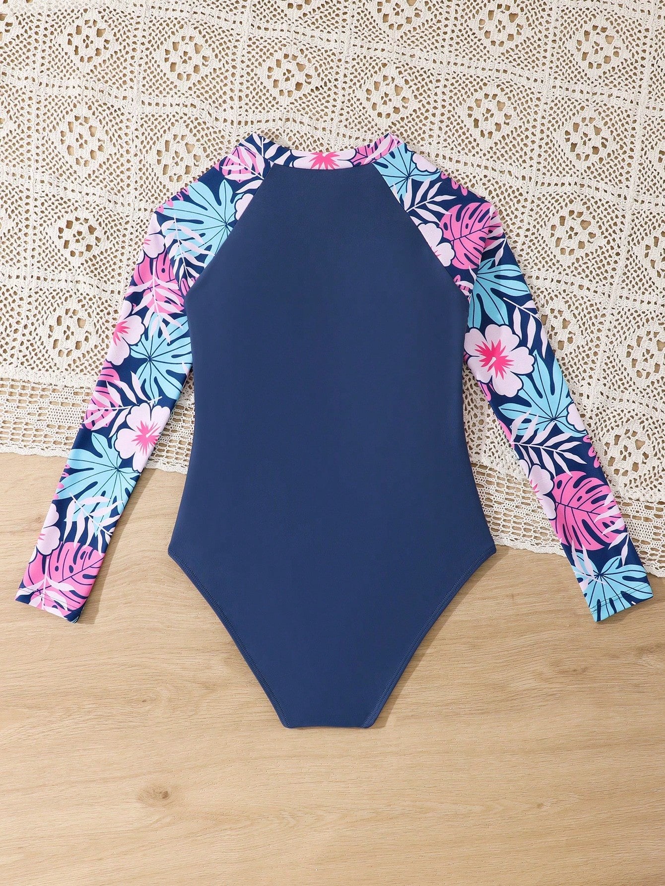 Vista trasera del traje de baño de manga larga en color azul con mangas florales.