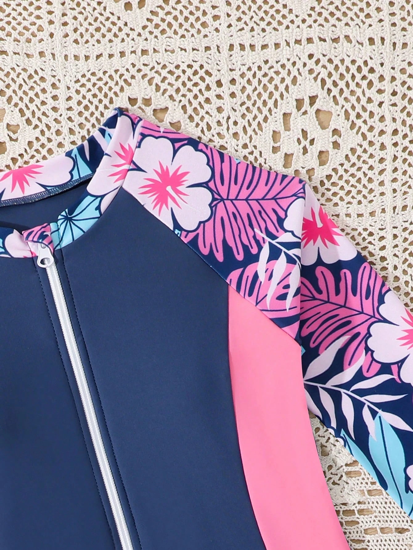 Detalle del cuello y mangas con estampado floral del traje de baño para niñas.
