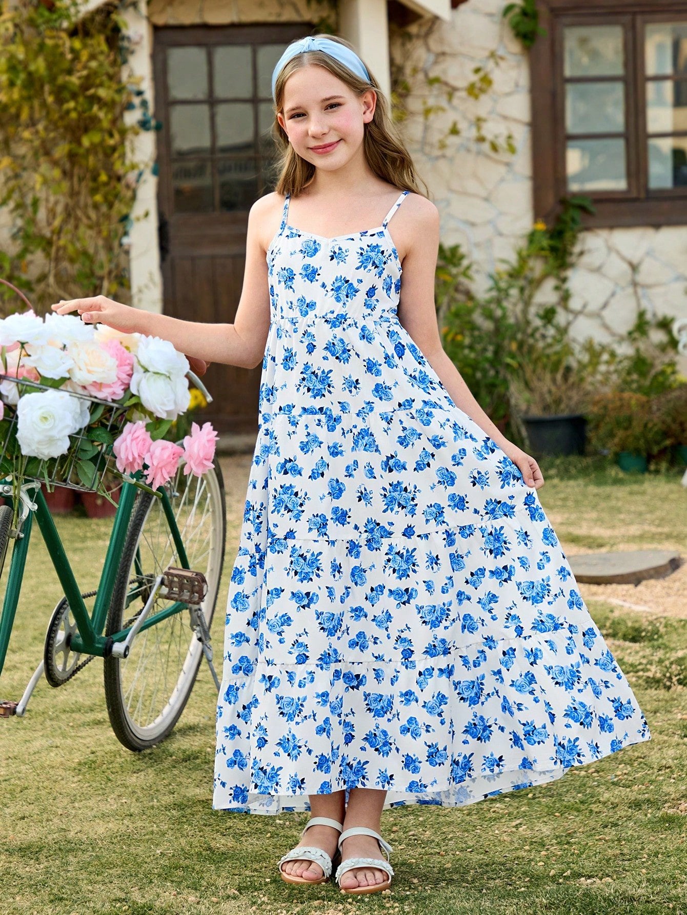 Vestido largo azul floral con abertura para niña, vista frontal mostrando tirantes finos y falda amplia.