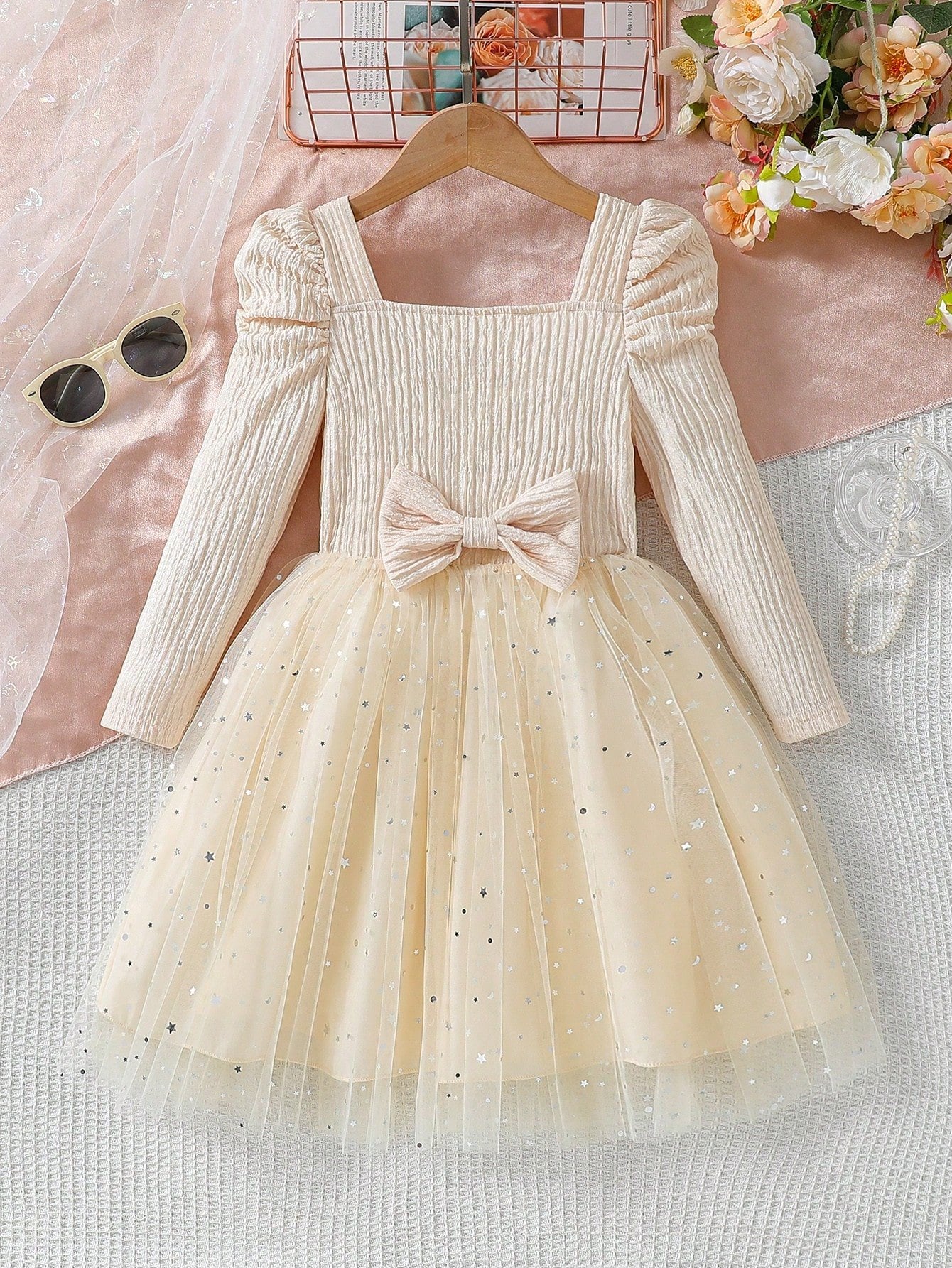 Vestido albaricoque con tul y lazo para niña, vista frontal mostrando falda brillante y detalle fruncido.