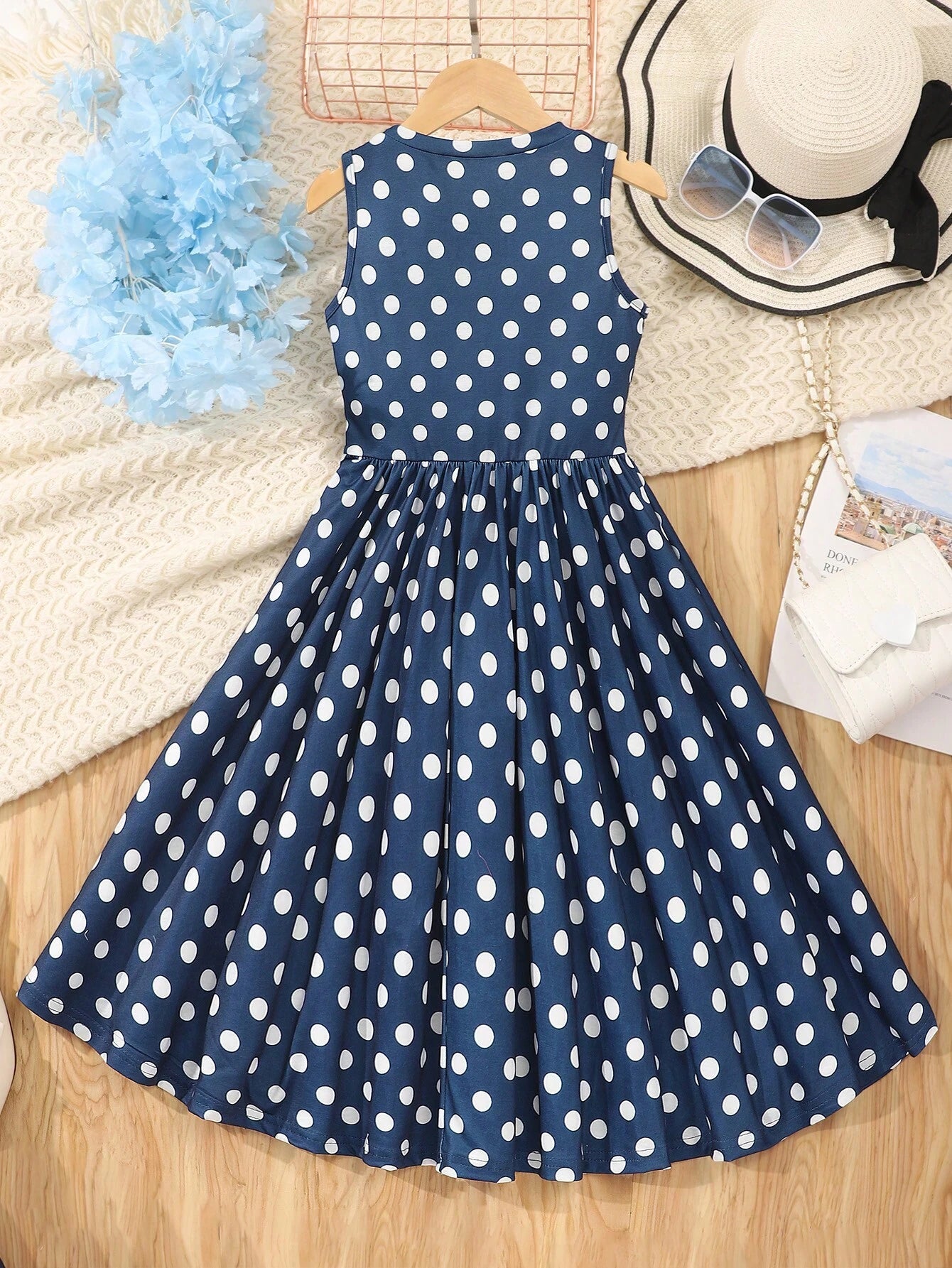 Vista trasera del vestido midi azul con lunares para niñas, con cremallera y talle alto.