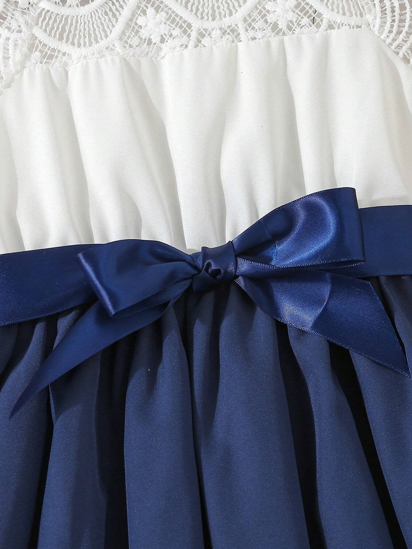 Lazo azul y detalle de la falda plisada del vestido azul con encaje para niña.