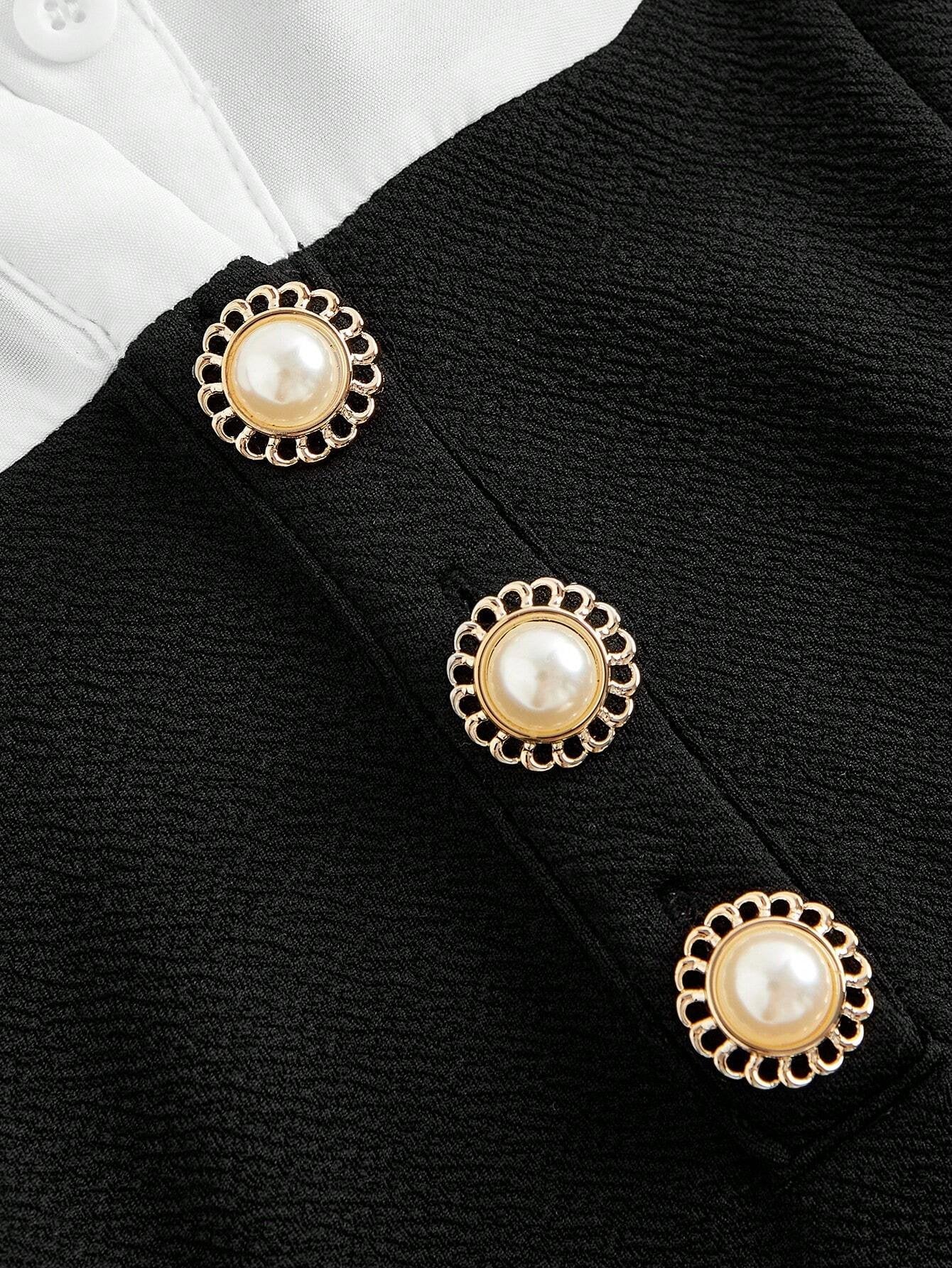 Primer plano de la blusa blanca con cuello camisero y mangas abullonadas.