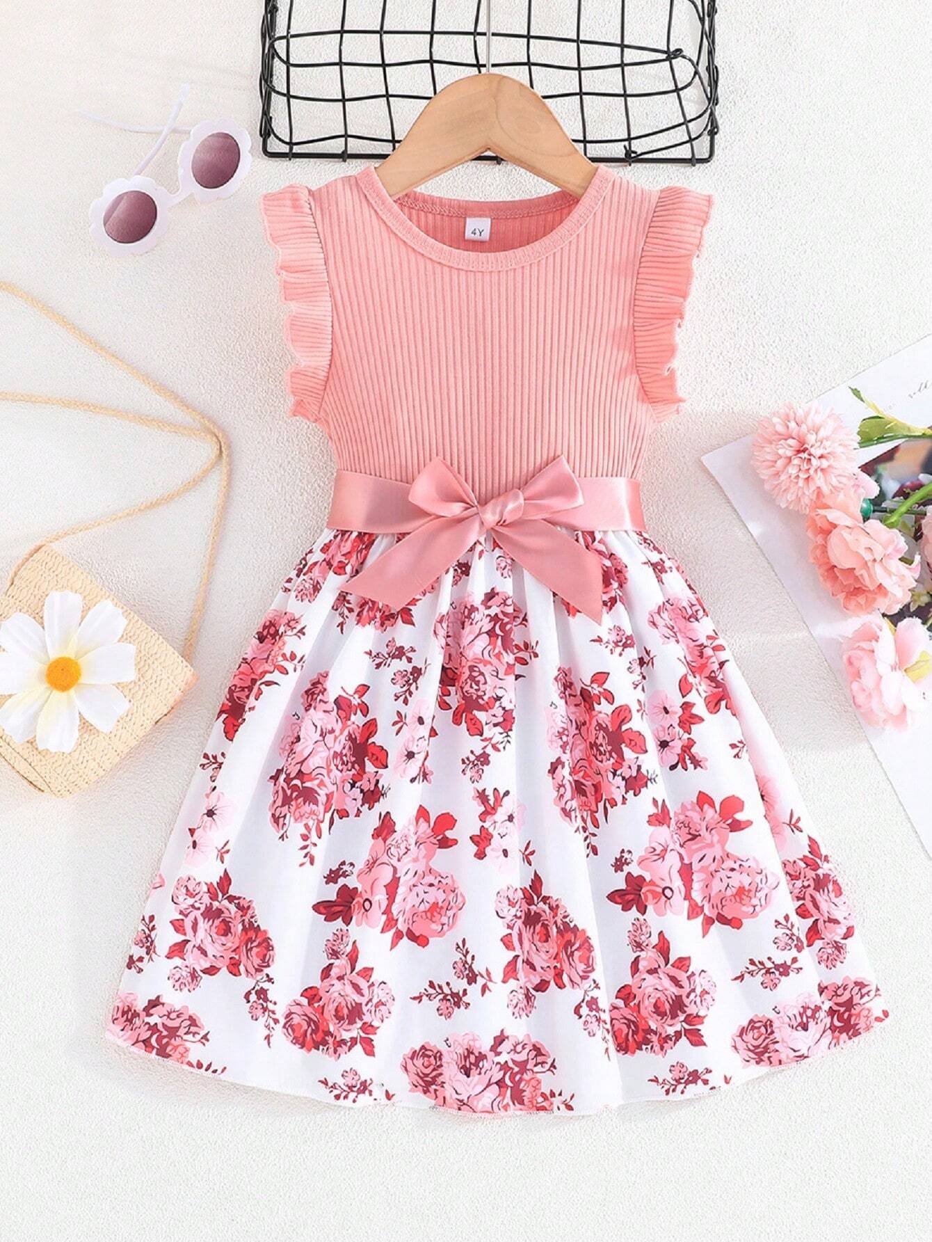 Vestido floral para niña con moño y volantes en los hombros.