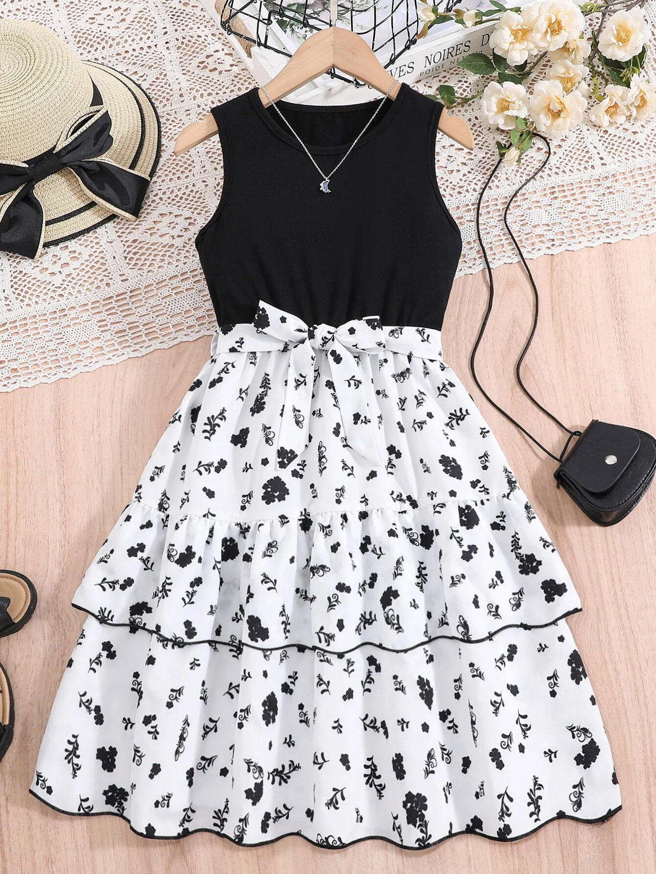 Vestido midi blanco y negro con cinturón para niña, vista frontal con falda en capas y cinturón ajustable.