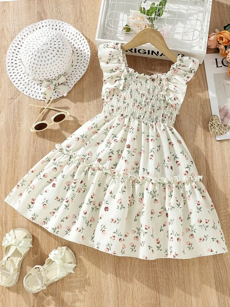 Vestido crema con estampado floral, volantes en los hombros e incluye sombrero a juego.