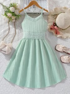 Vestido verde con tirantes finos y encaje para niñas, vista frontal sobre fondo decorativo.