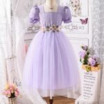 Vestido elegante morado para niña con falda de tul y detalles florales visto de frente.