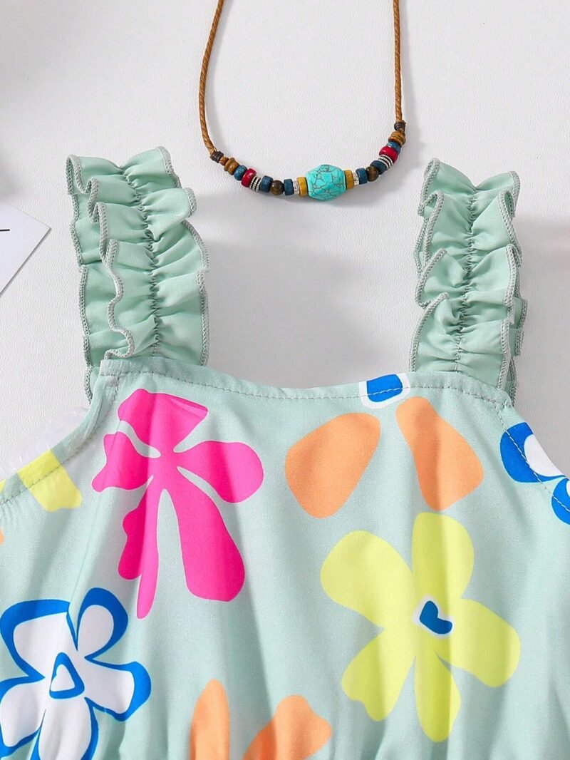 Detalle tirantes: Detalle de tirantes con volantes fruncidos del vestido verde floral para niña.