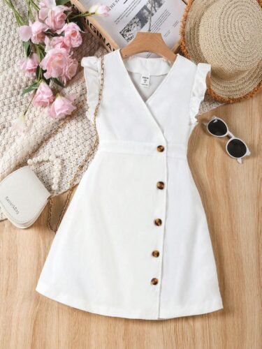 Vestido blanco para niñas con botones decorativos y volantes, exhibido en percha con accesorios de verano.