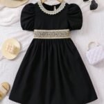 Vestido negro con encaje dorado y manga farol.