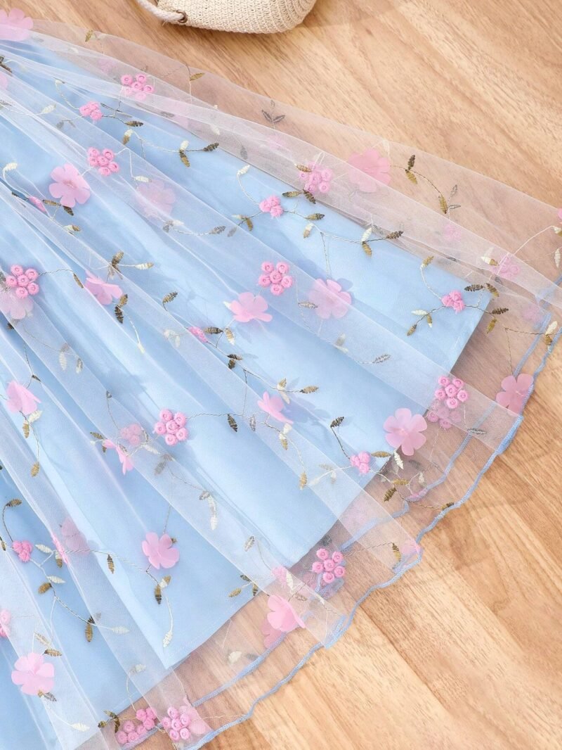 Detalle del tul bordado con flores y apliques del vestido azul con tul bordado y apliques para niña.