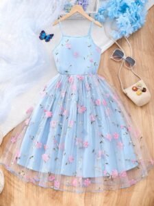Vestido azul con tul bordado y apliques para niña, vista frontal mostrando tirantes finos y falda campana.