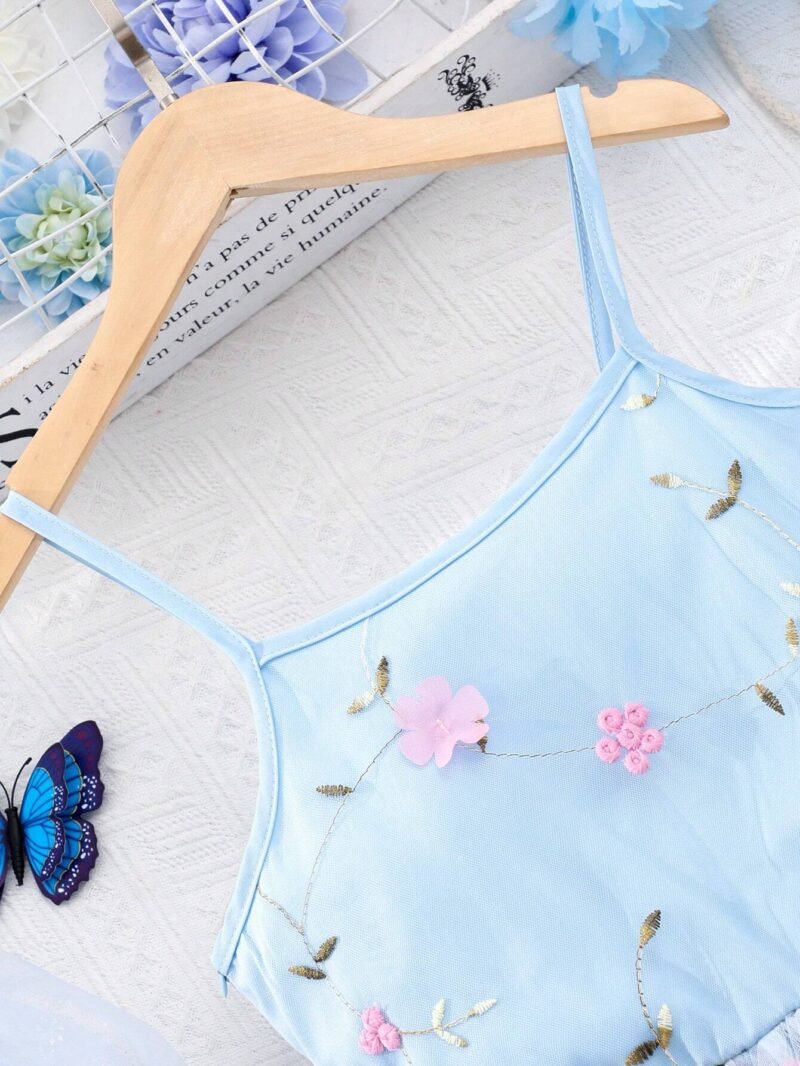 Detalle del escote con tirantes finos y bordado delicado del vestido azul con tul bordado y apliques para niña.