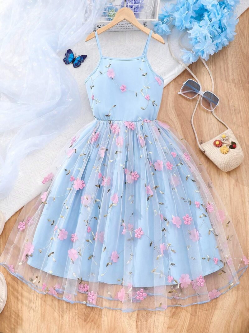 Vestido azul con tul bordado y apliques para niña, vista frontal mostrando tirantes finos y falda campana.