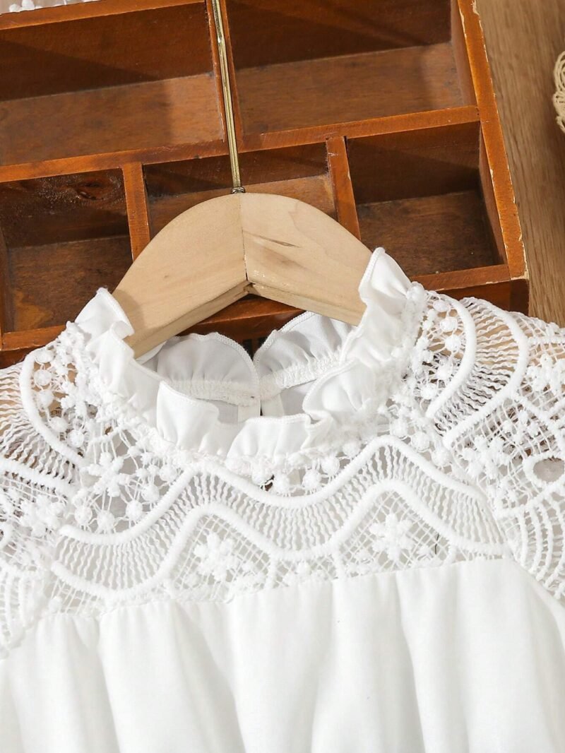 Detalle del escote con encaje y cuello alzado del vestido azul con encaje para niña.