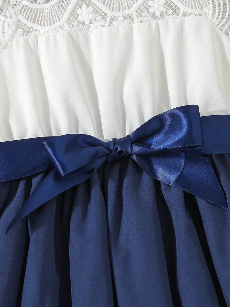 Lazo azul y detalle de la falda plisada del vestido azul con encaje para niña.