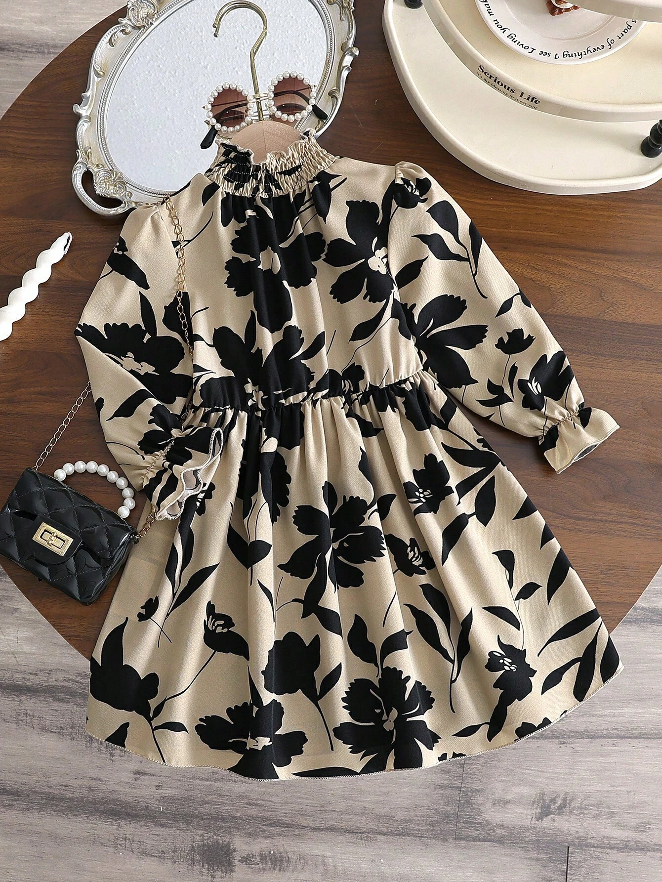 Vestido floral para niñas con cuello alzado y manga larga en fondo beige.